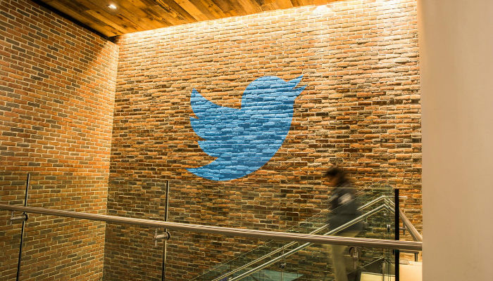 Twitter logo on a brick wall